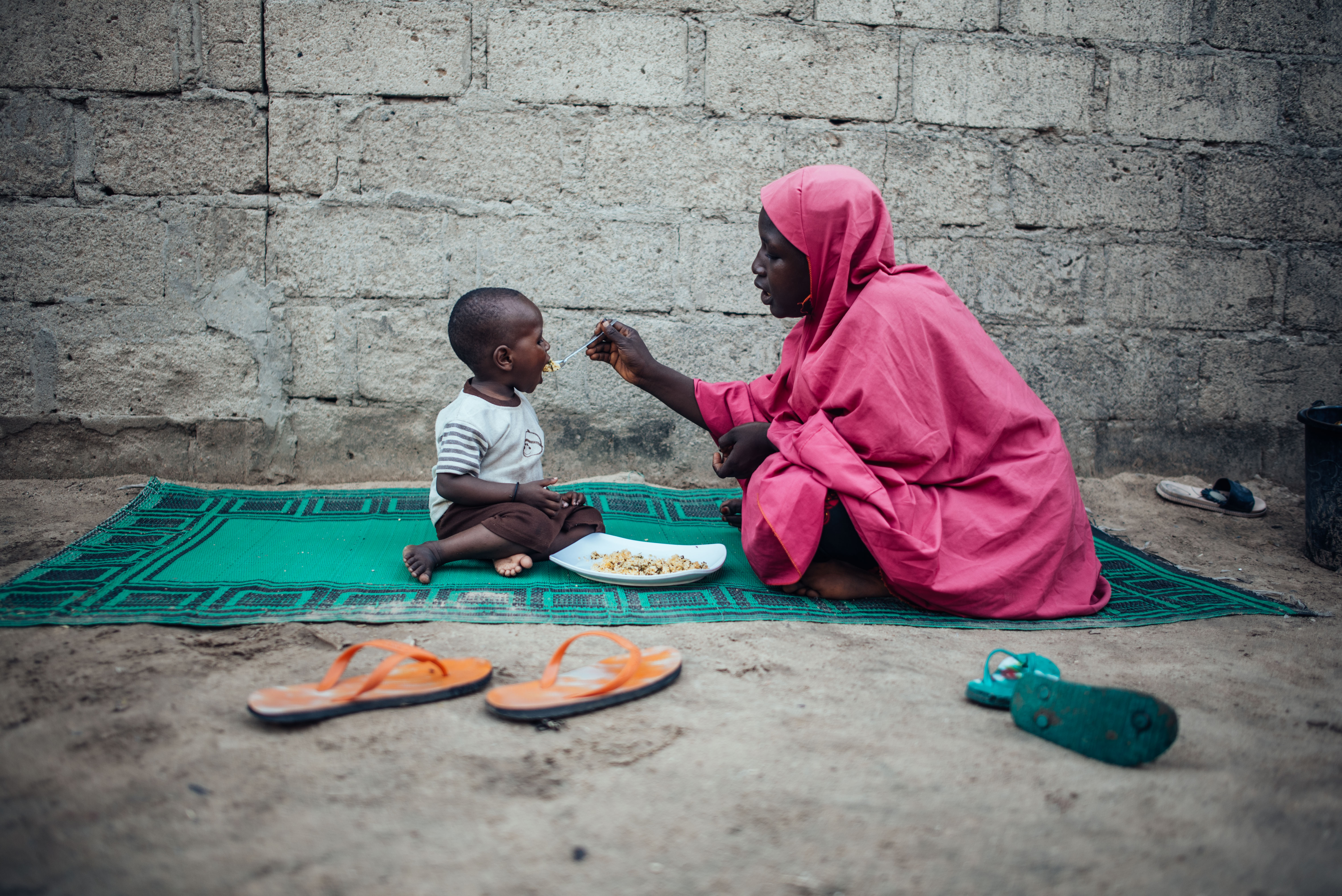 Bilkisu Ahmed feeds her son at their home in Nigeria.